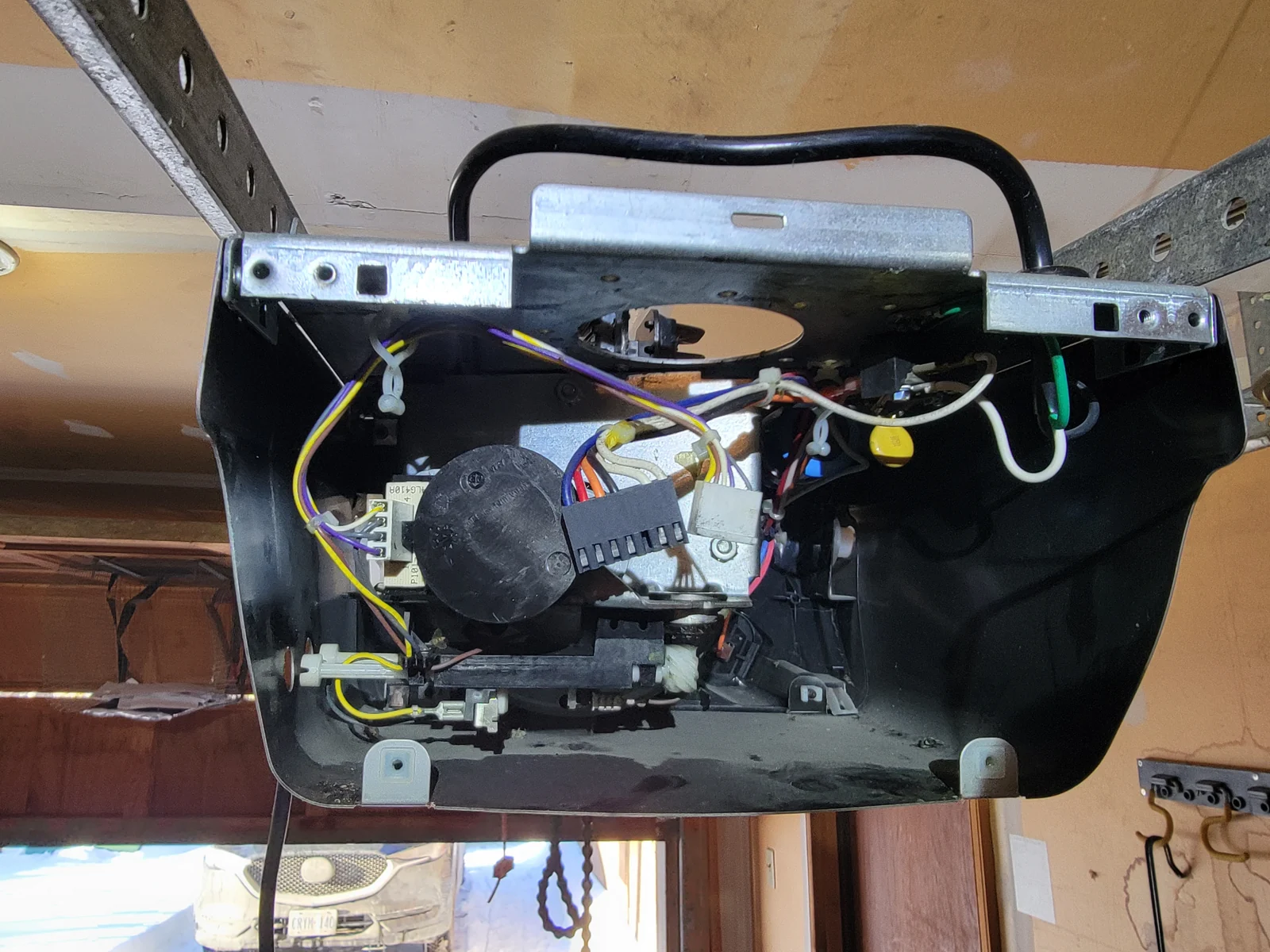 Open garage door opener housing showing the motor, wiring and internal mechanism.