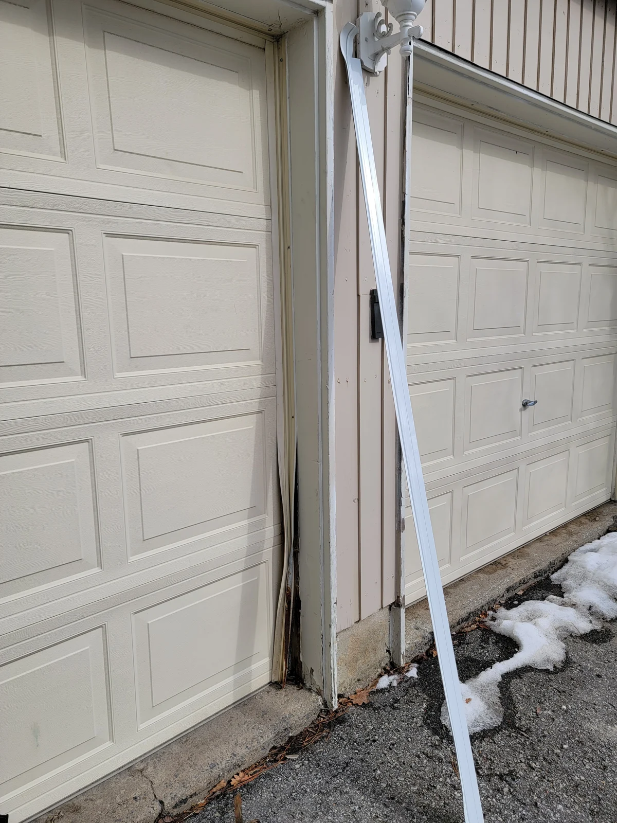 Before: Detached perimeter weather strip beside a garage door.