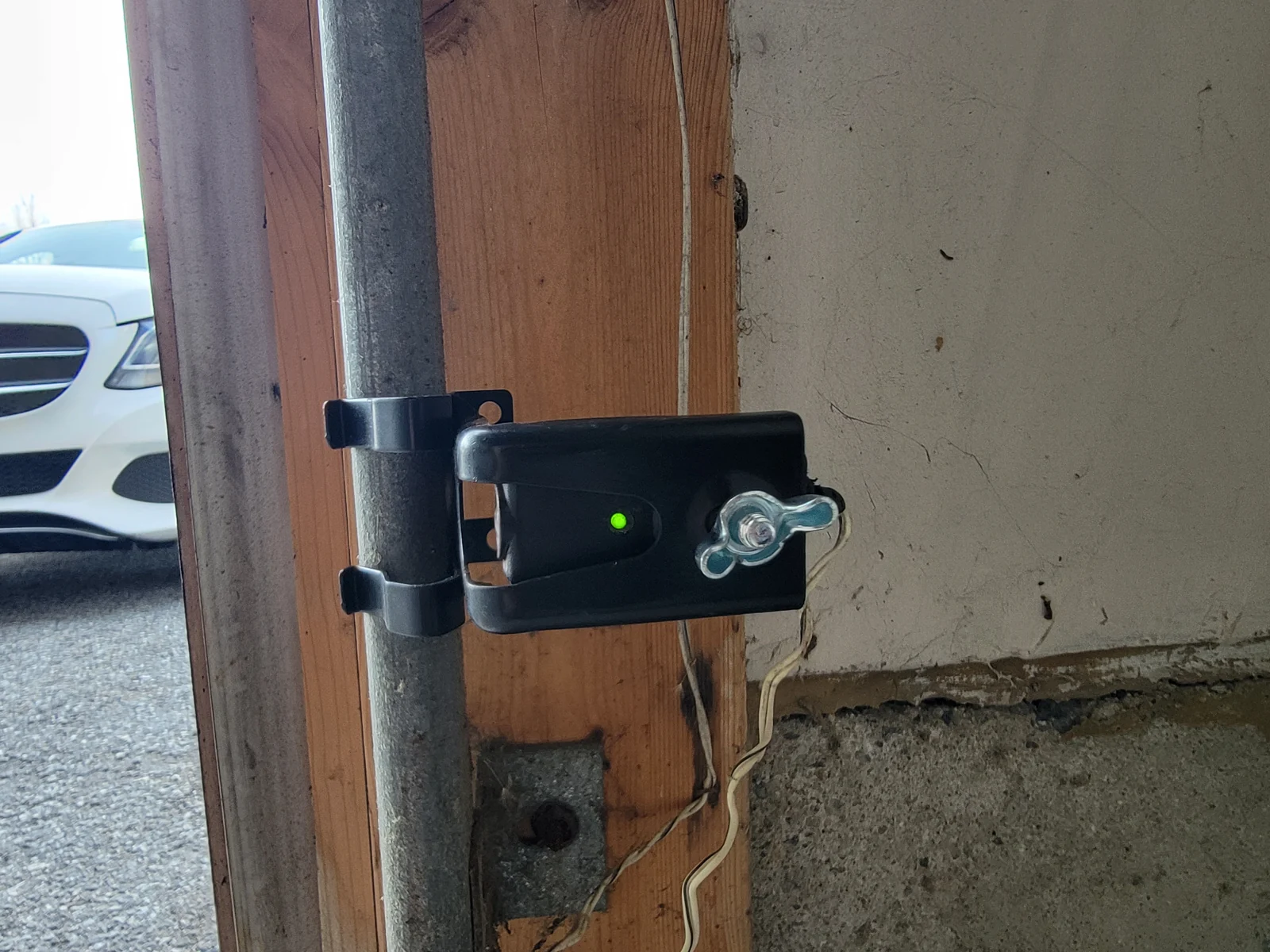 Garage-door safety photoeye near the lower track.