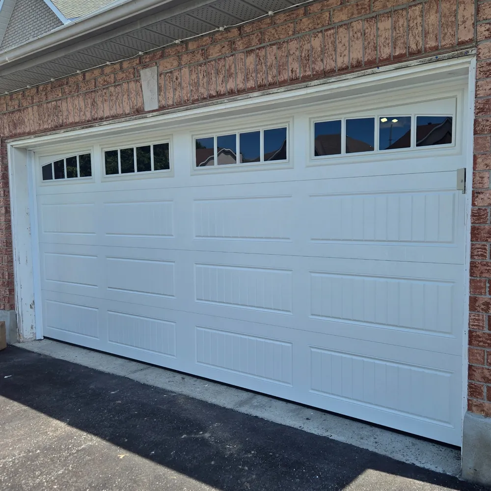 White carriage-style double garage door with gridded top windows.